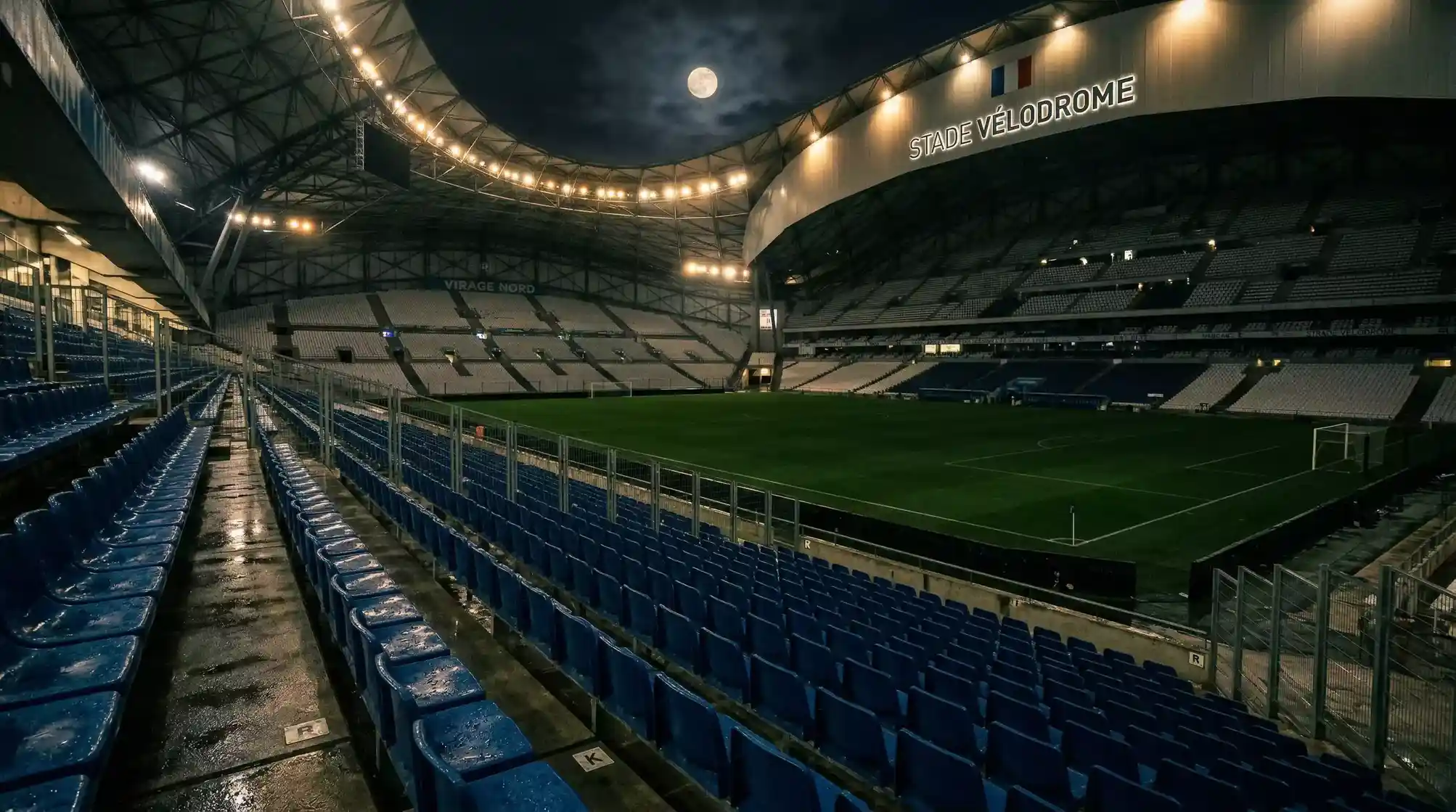 Grada de un estadio de futbol frances con asientos vacios y el cesped de fondo