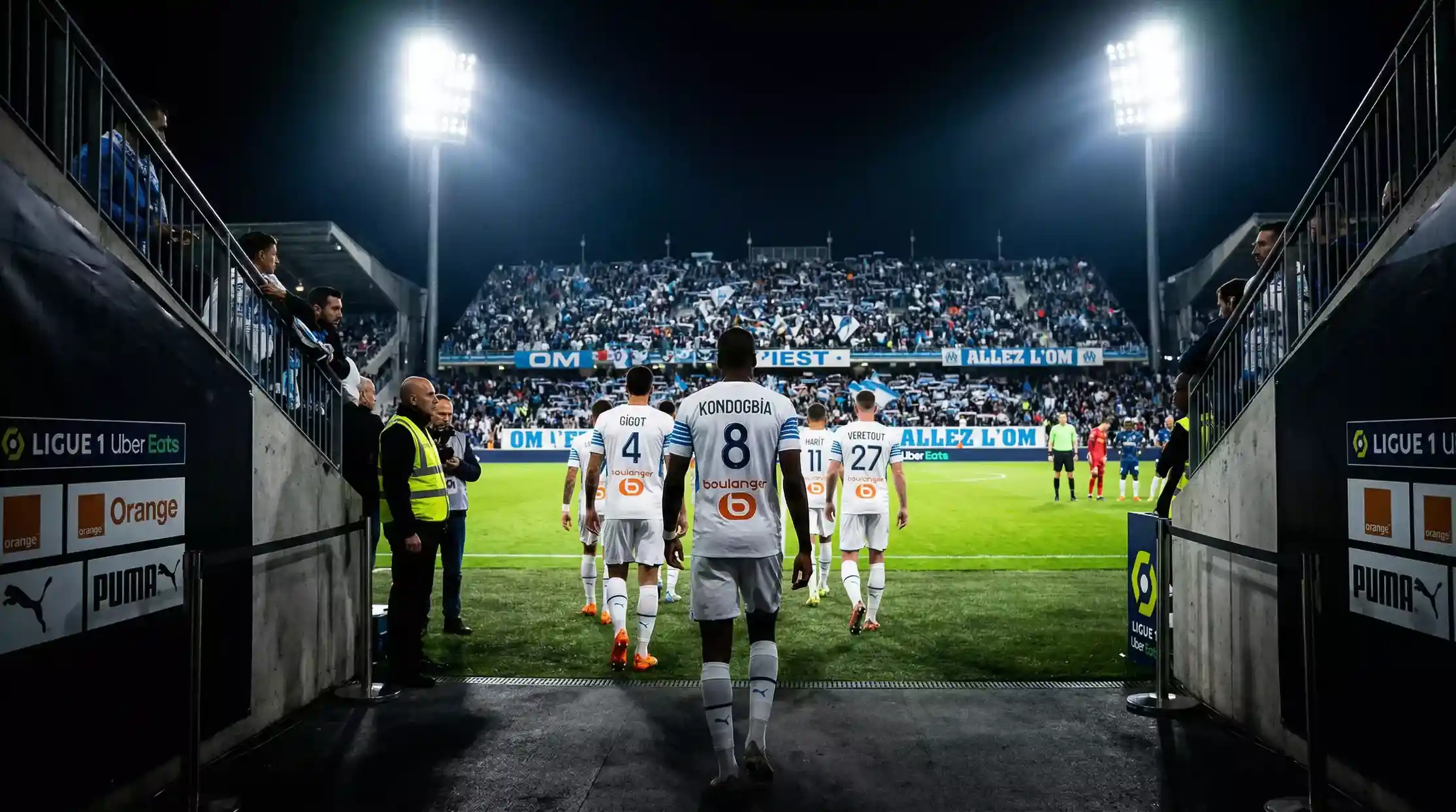 Jugadores de futbol de la Ligue 1 saltando al cesped desde el tunel de vestuarios antes de un partido