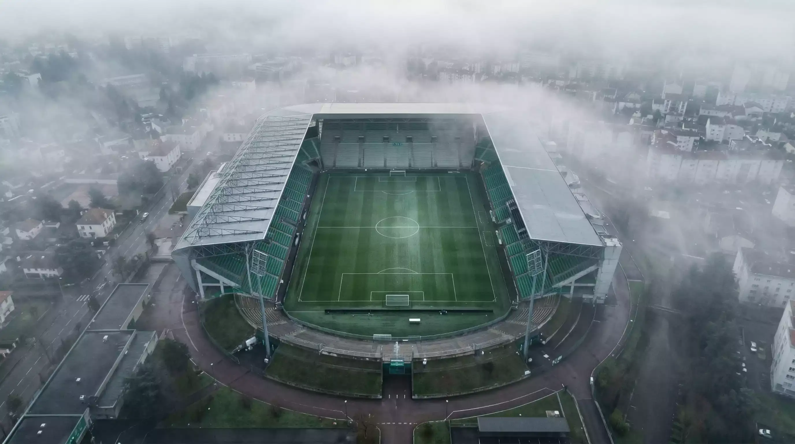 Vista aerea de un estadio de futbol en Francia con la ciudad al fondo