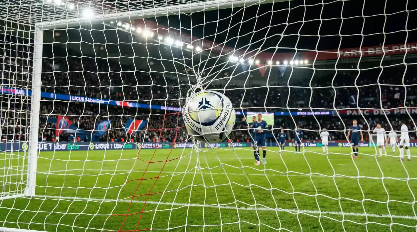 Balon de futbol entrando en la red de una porteria en un estadio de la Ligue 1